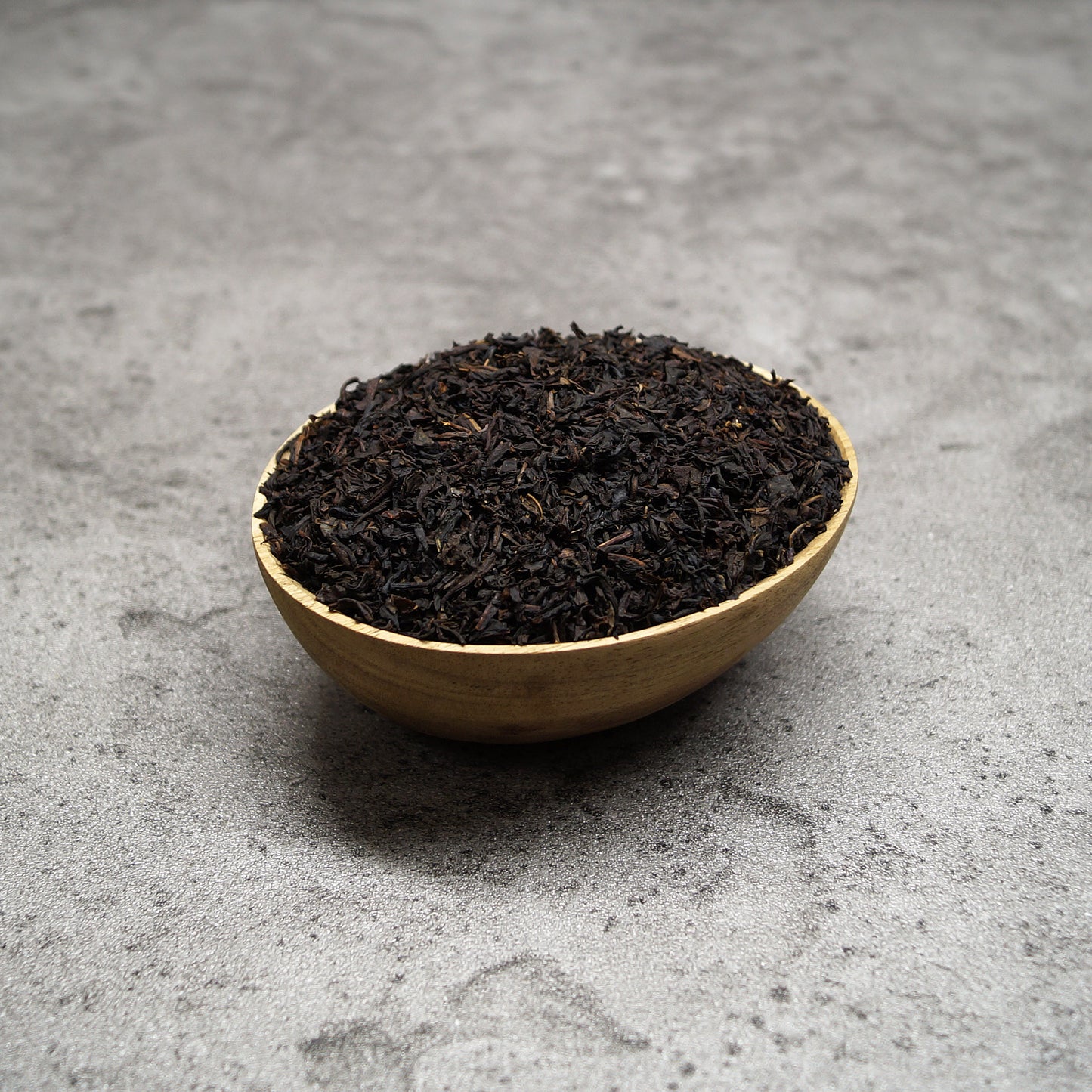 Black tea vanilla blend in a wooden bowl with loose leaf tea