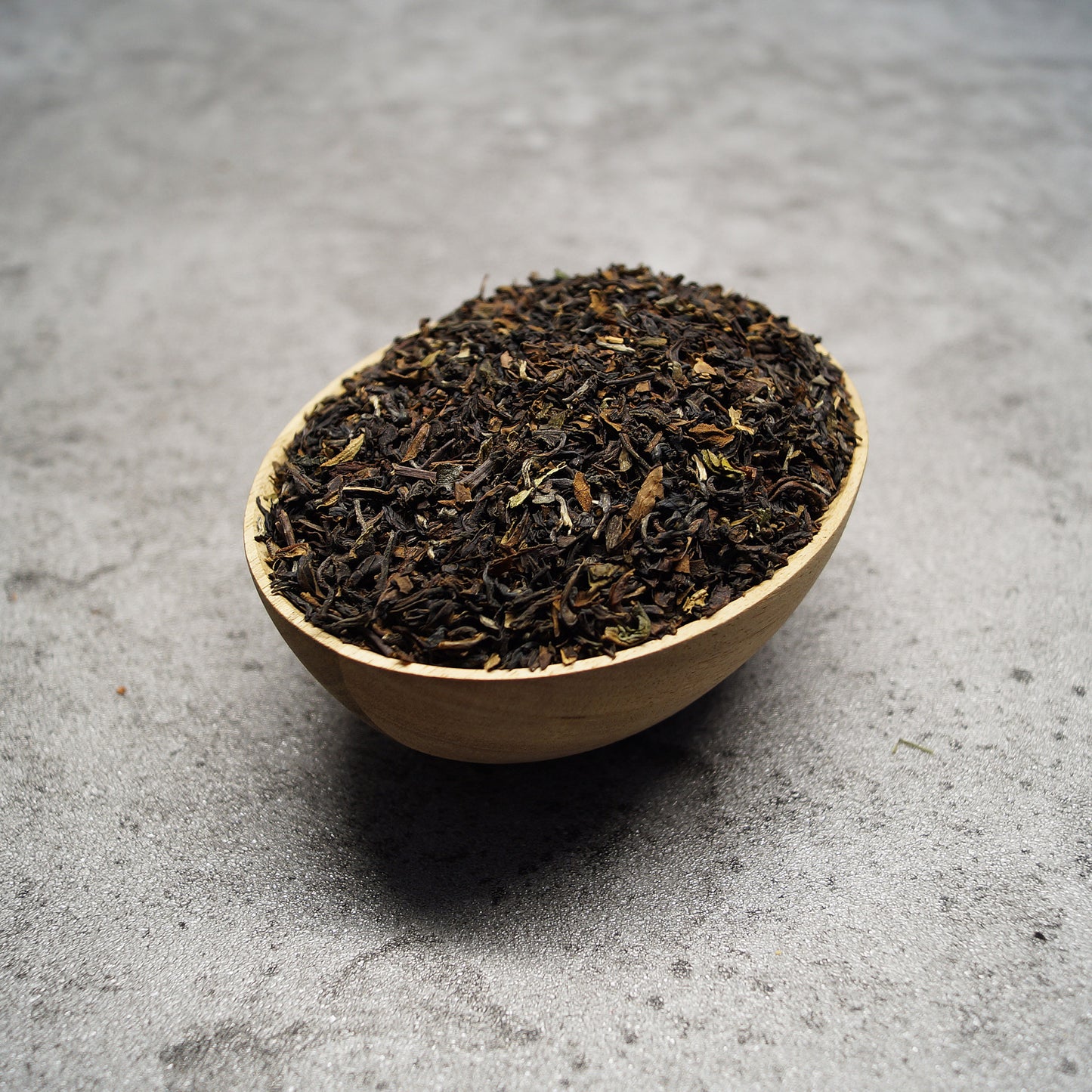 Loose leaf Darjeeling Second Flush black tea leaves on wooden surface