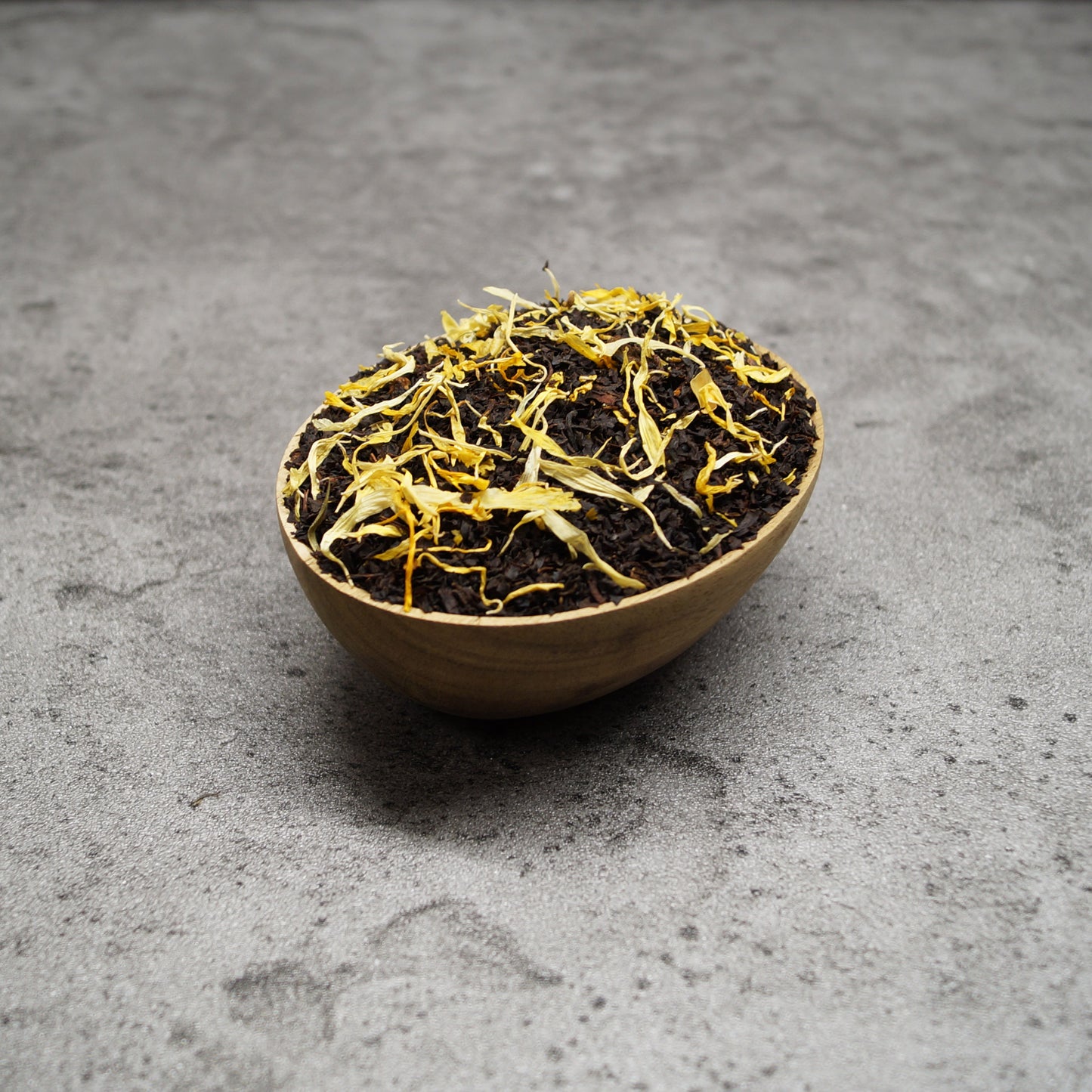 Orchard peach black tea leaves in a wooden bowl