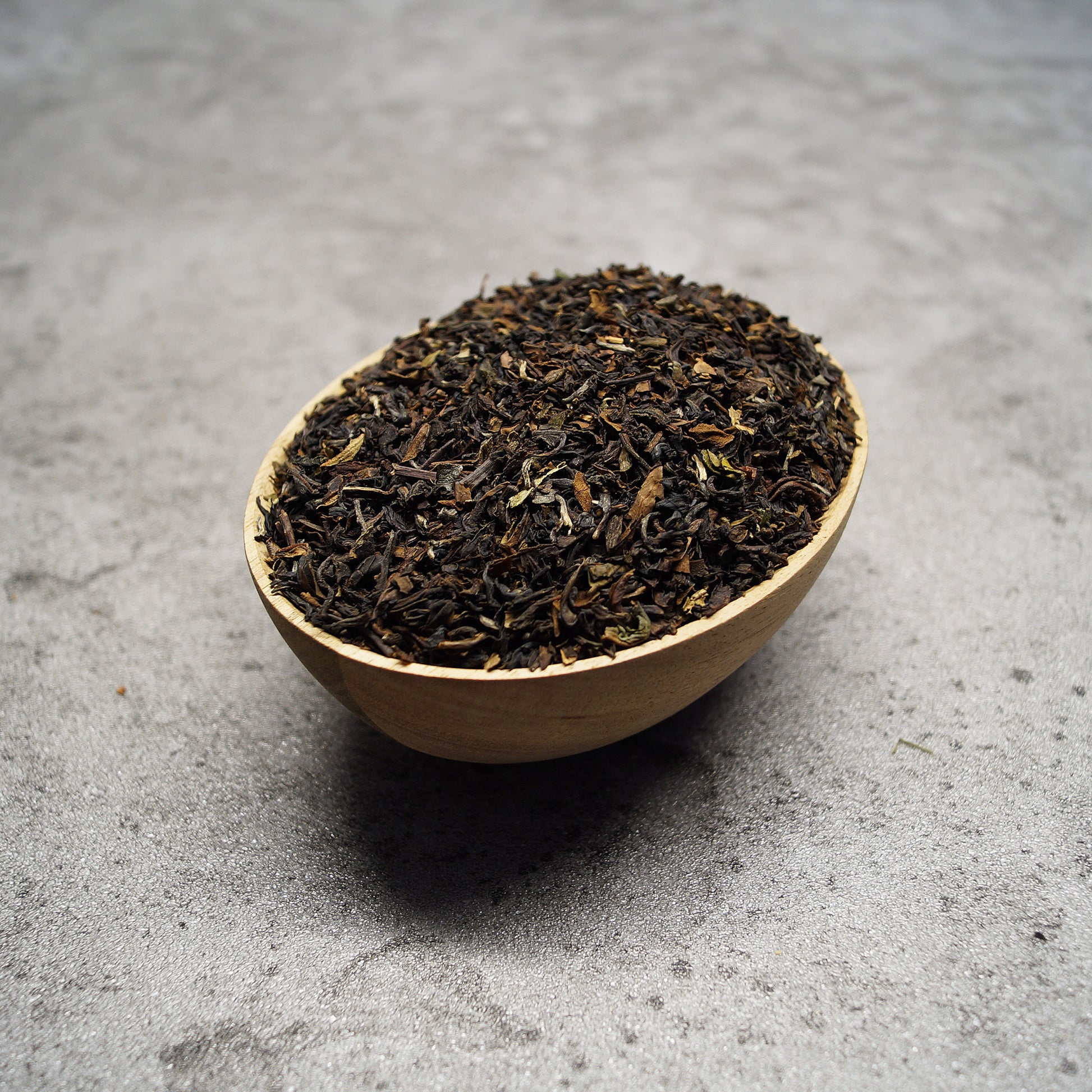 Loose leaf Darjeeling Second Flush black tea leaves on wooden surface