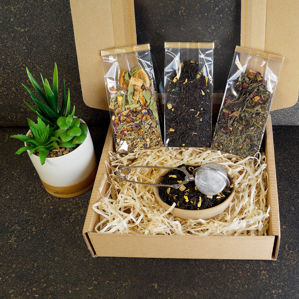 Open view of luxury tea gift set featuring black tea and tea infuser tong